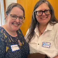 Two event attendees standing together and smiling